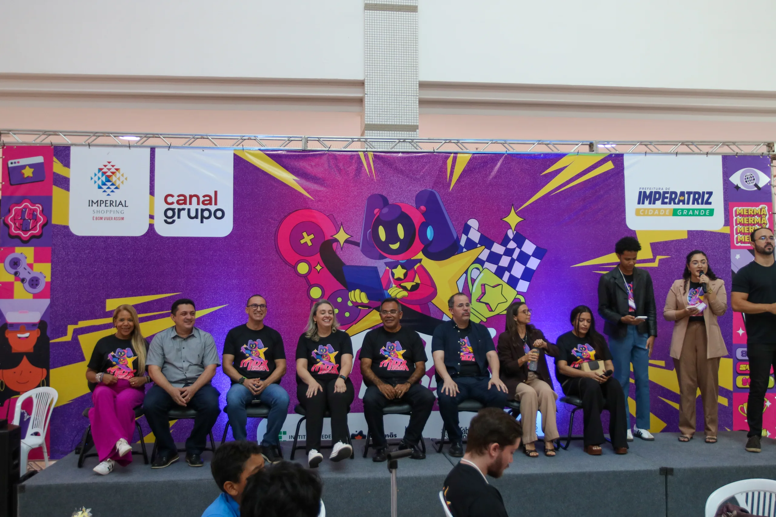Estudantes apresentando projeto de robótica na arena do MDX25
